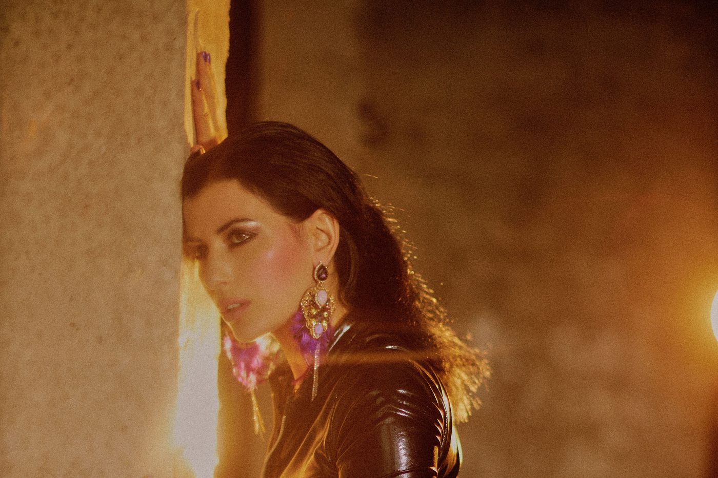Femme en latex noir sous une lumière chaude